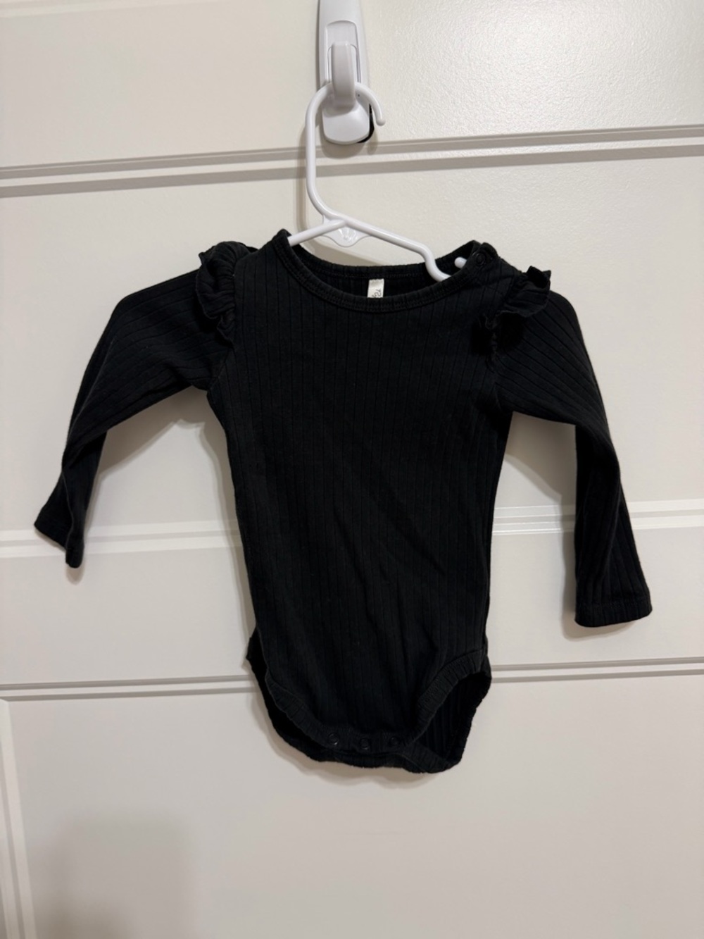 Rylee + Cru Black Ribbed Long-Sleeve Baby One-Piece with Ruffled Shoulders
